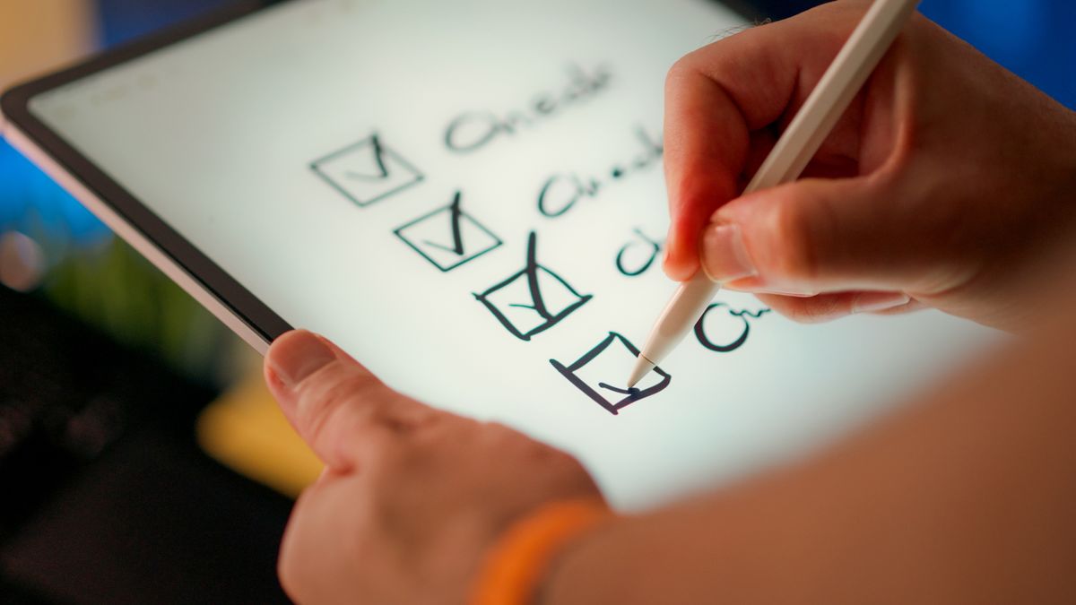 Hand marking off a digital audit checklist on a tablet