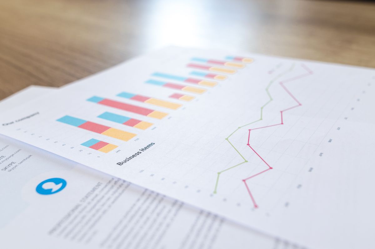 Printed financial report with bar and line charts on a desk