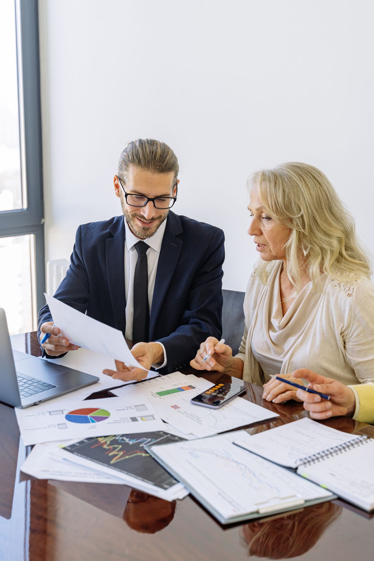 Consultant reviewing financial documents and charts with a client